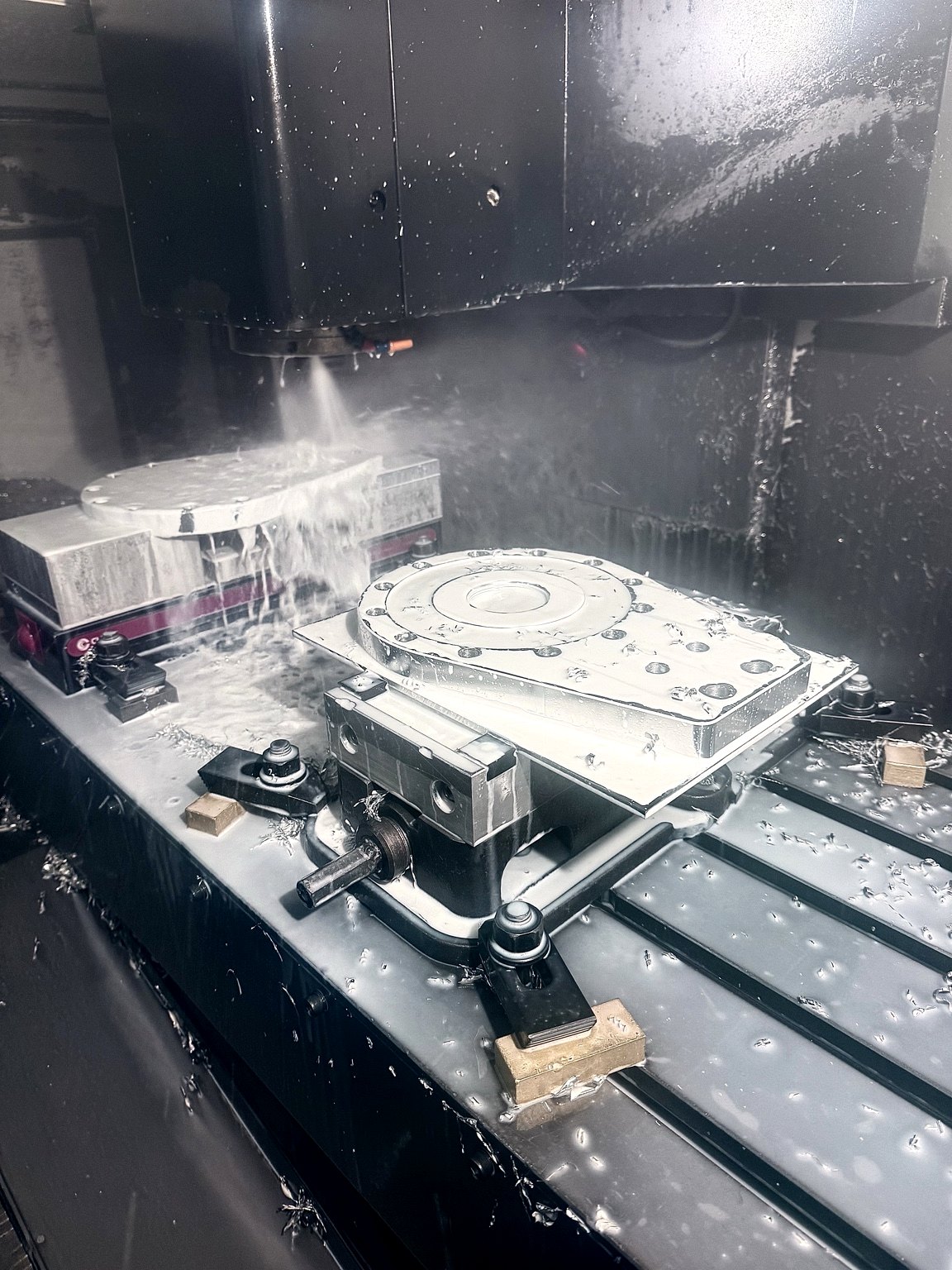 CNC machining in progress with coolant during cutting