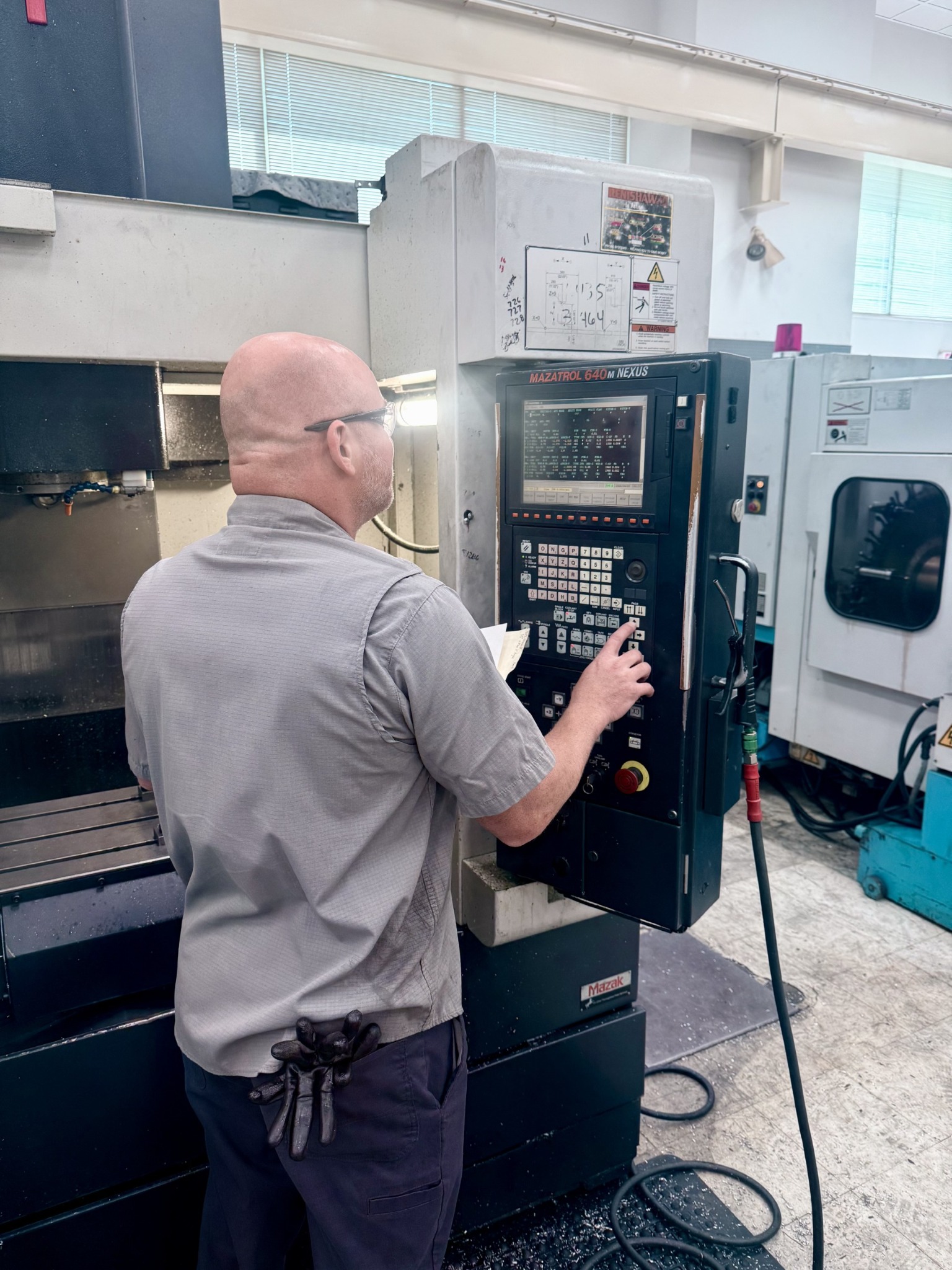 Quality Mould employee setting up a CNC machine to run a part