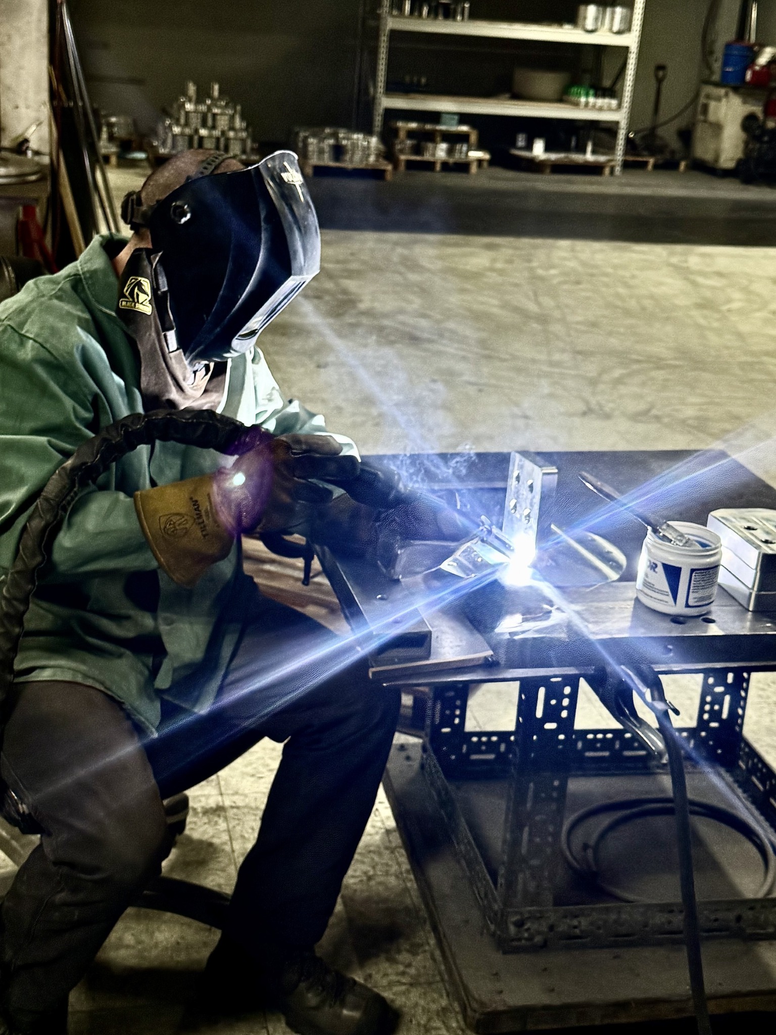 Welder fabricating a machined industrial component